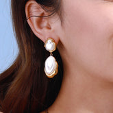 Model wearing asymmetric pearl earrings styled with minimalist outfit
